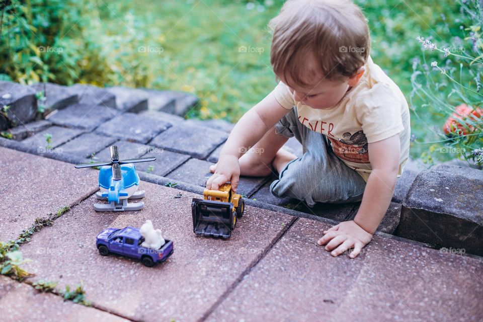 little boy playing with cars