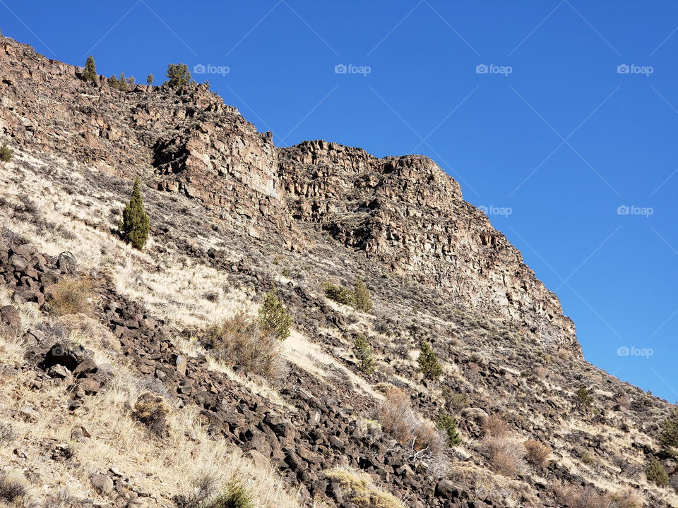 Hills along the Crooked River Highway made from andesite and basalt flows on a sunny fall day with clear blue skies in Central Oregon. 