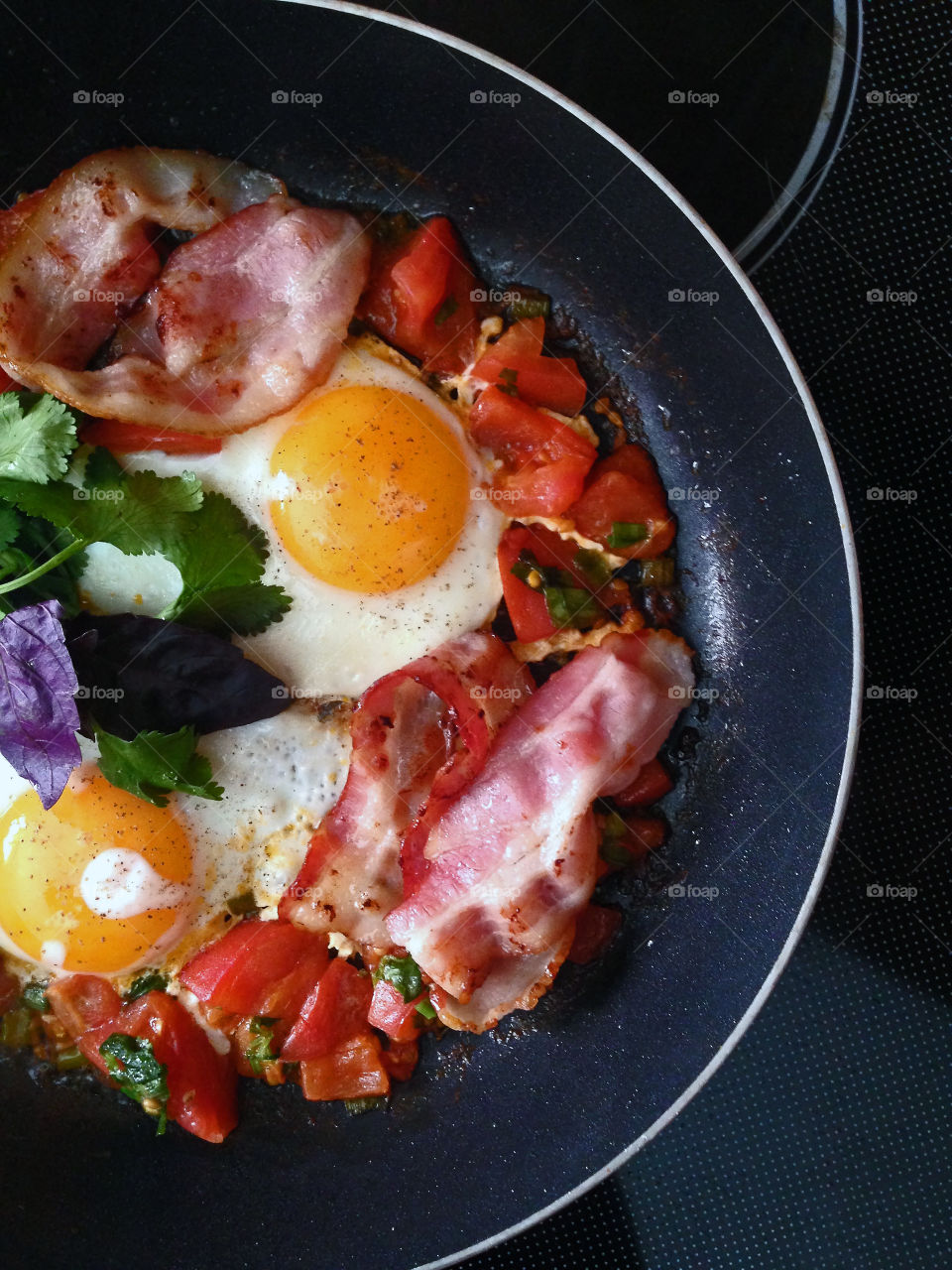 Fried eggs with bacon and tomatoes 