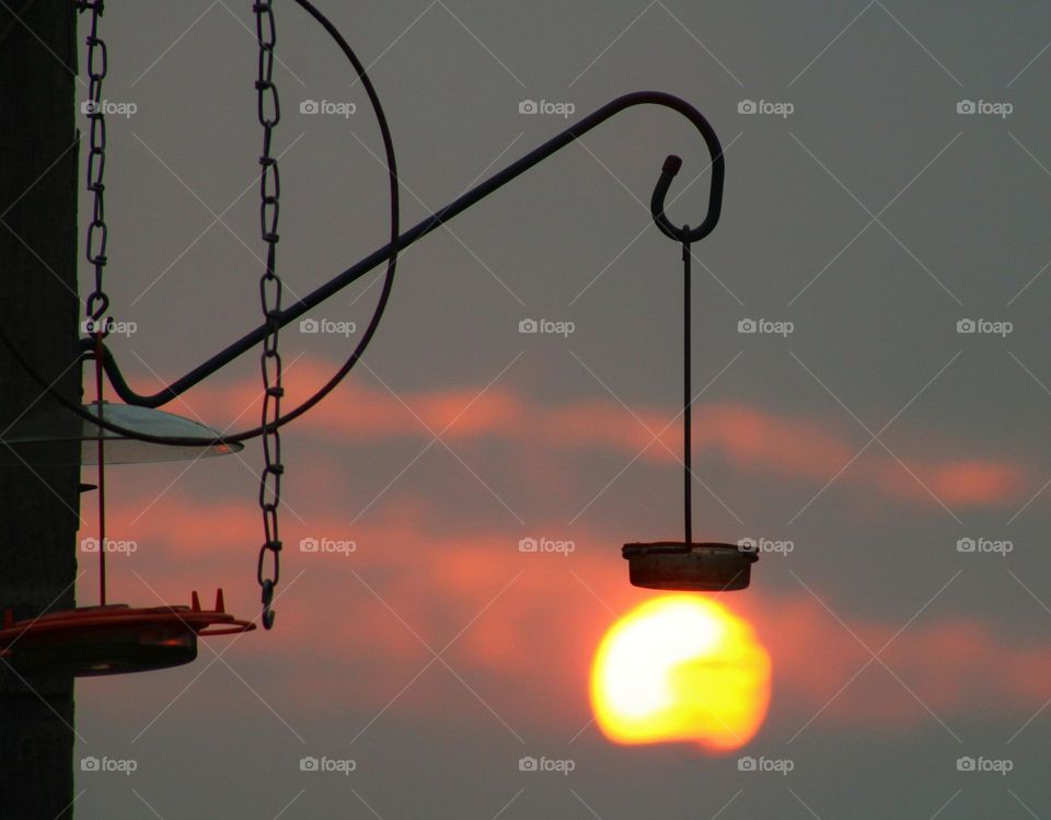 silhouette of metal chains and bird feeder