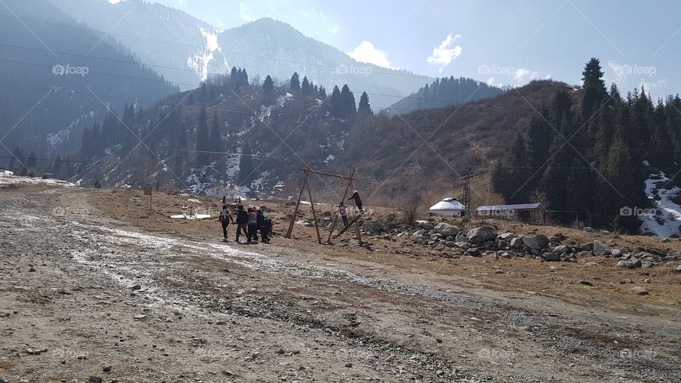 people on a swing in mountains