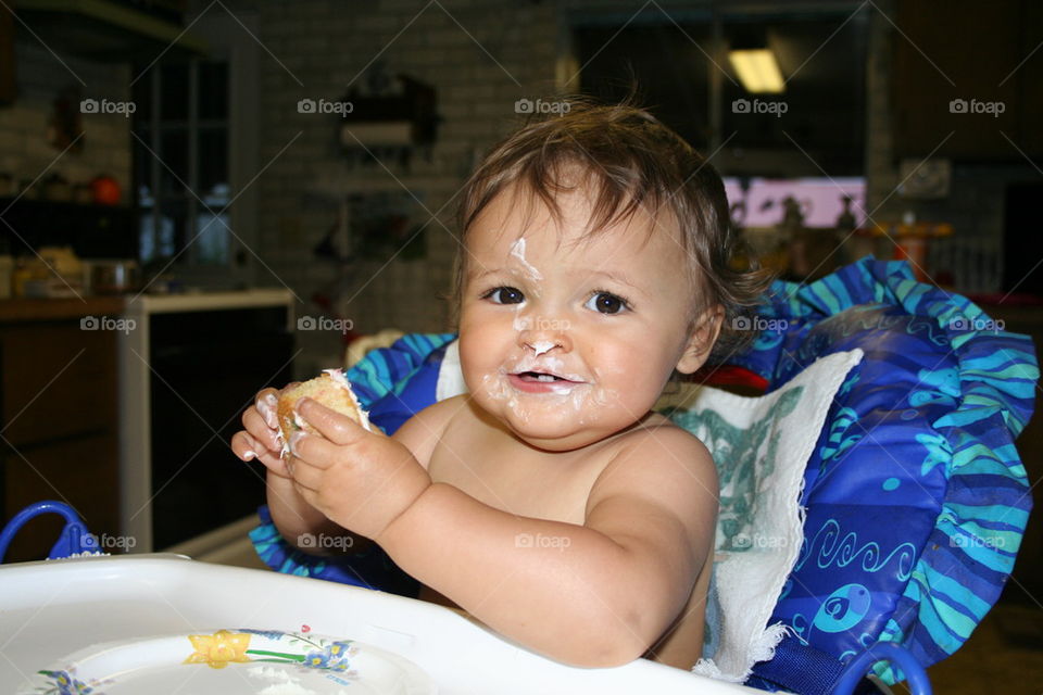 Cute little girl eating a cupcake.