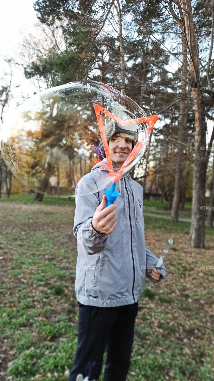 guy blowing bubbles in the park