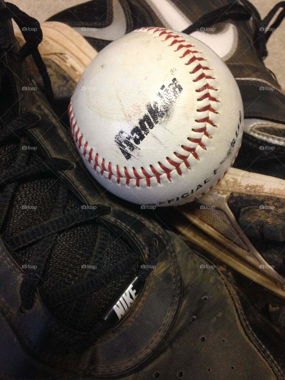 A well loved game. Baseball on top of well used baseball cleats