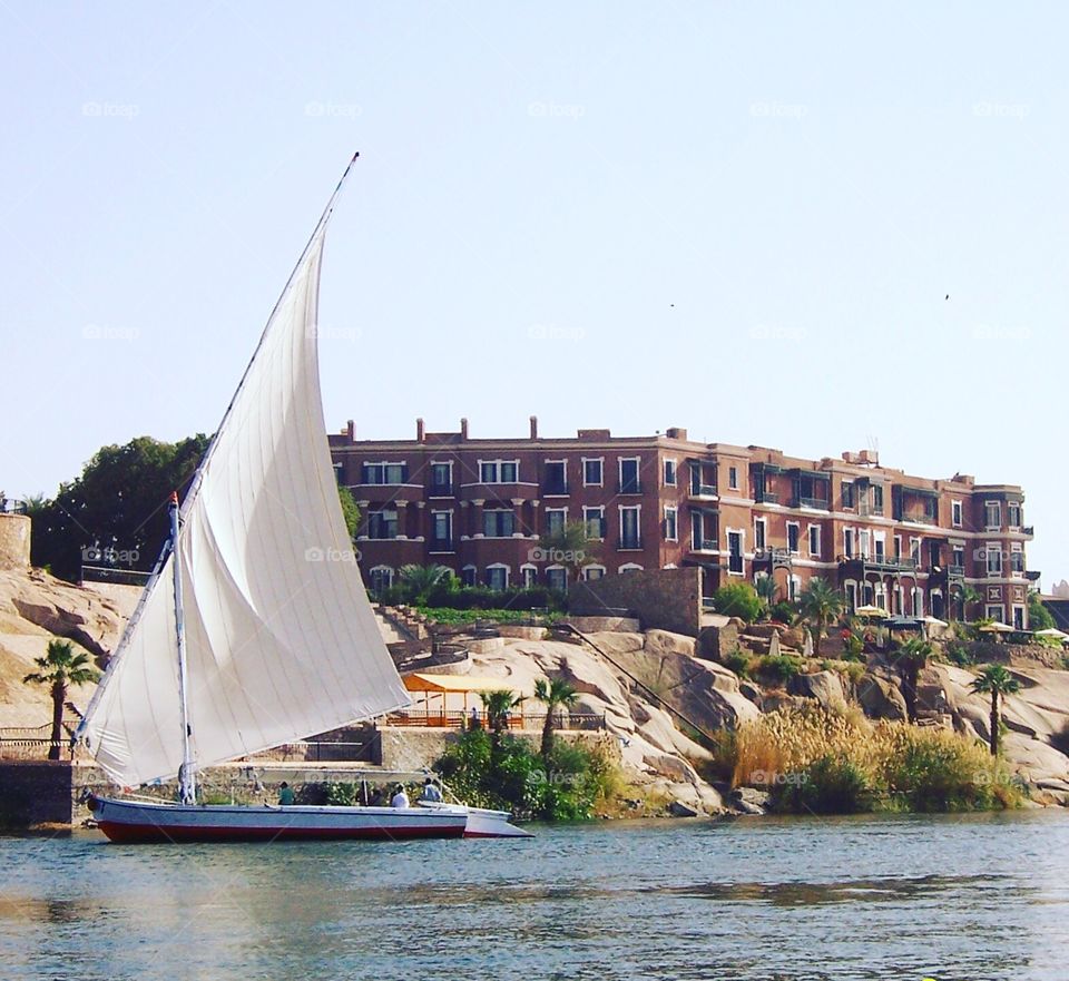 A felluca on the Nile River with the Old Cataract Hotel where Agatha Christie wrote her famous novel "Death on the Nile".