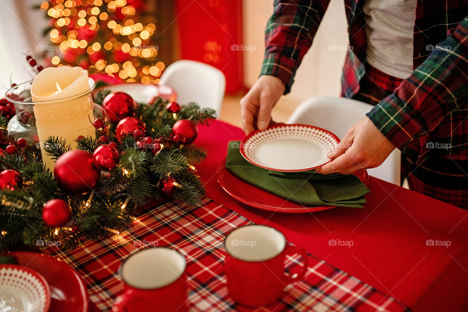 man sets a beautiful decorated winter table for a festive dinner.  Merry Christmas and Happy New Year.