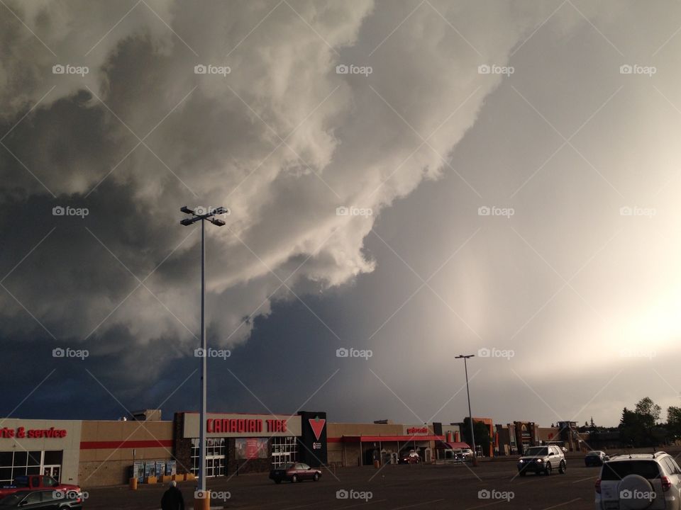 Freaky clouds . Intense sunshine, scary clouds, and soon after... A rainbow with lightning behind it!? :)