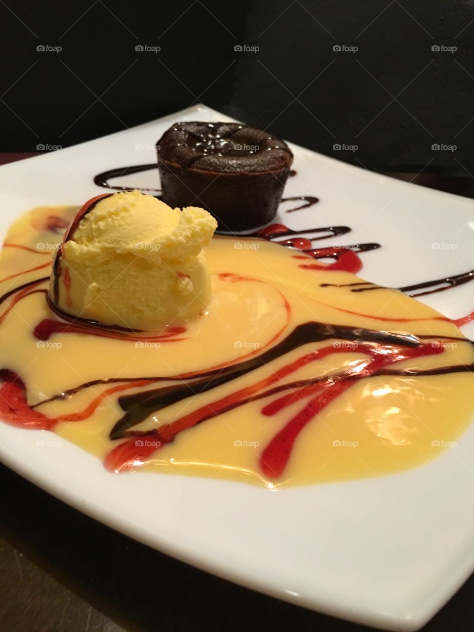 It’s time for a delectable dessert. A scrumptious lava cake, with a scoop of vanilla ice, covered in an array of sauces. 