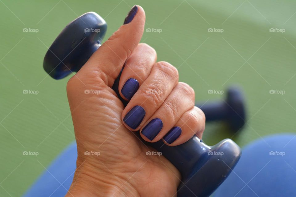 female hand with dumbbell, training  indoor