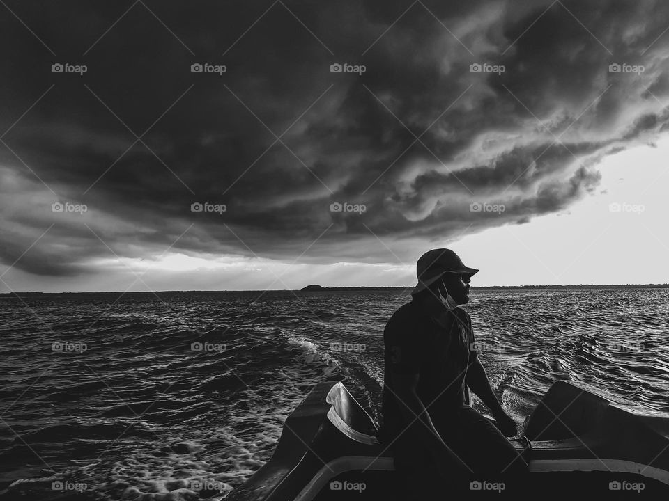 Racing away from the eye of the storm. Story clouds forming in the background over the island in the horizon.