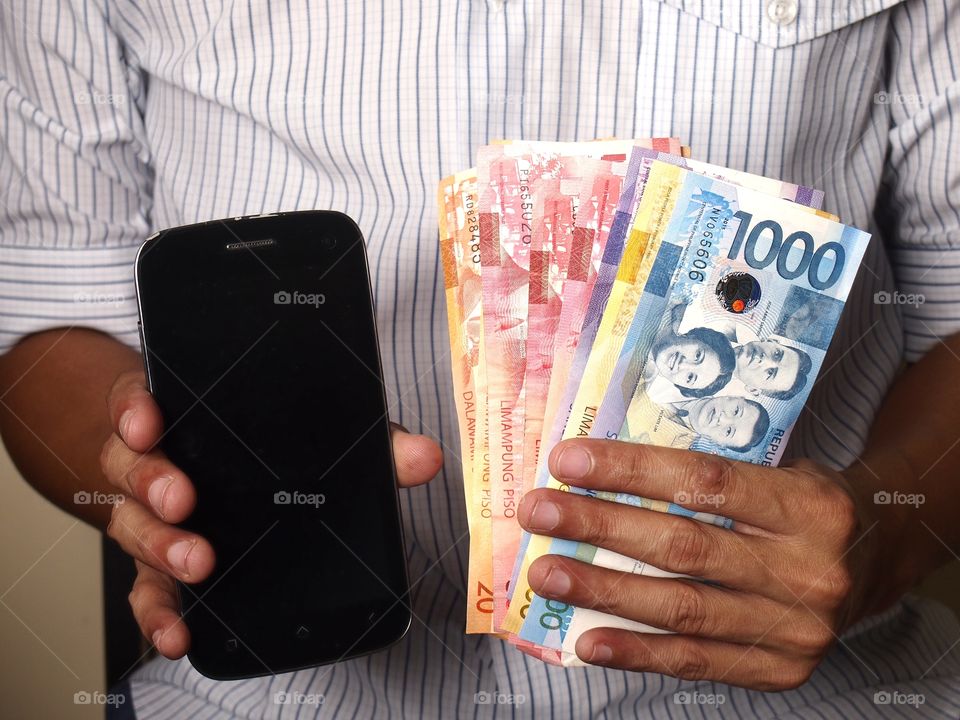 man holding phone and money. man holding phone and bills of money