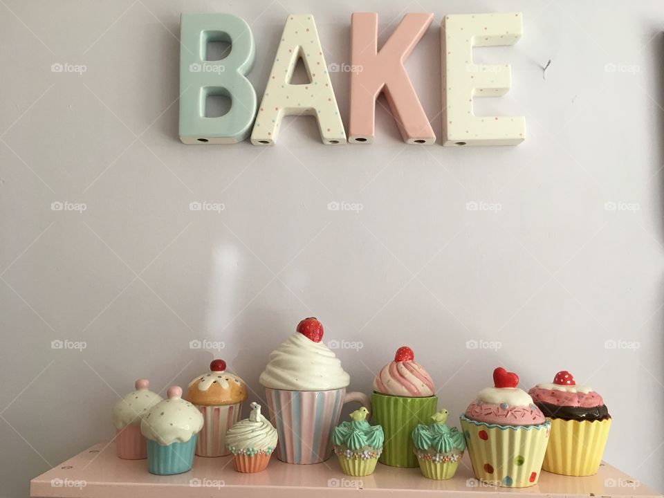 Ceramic Bake letters on a wall painted marshmallow colour with cupcake trinket boxes, mugs and containers 