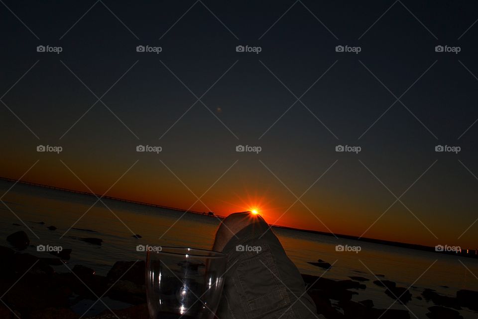 Playful sunset. Deep red sunset, sun 'resting' on the knee, south Australia Rocky beach, point Lowley. 