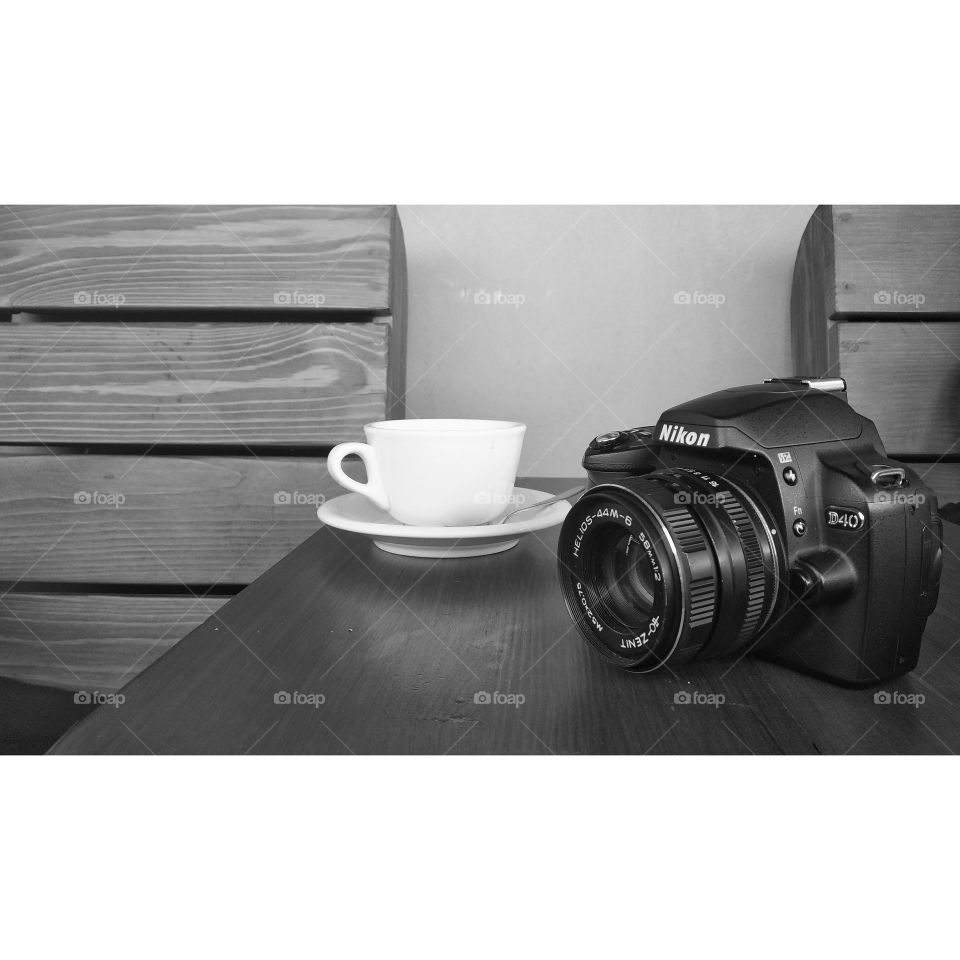 camera near a cup of coffee on a table in a cafe