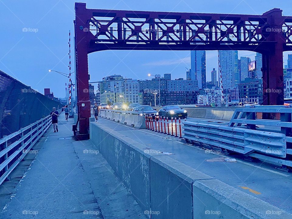 This is the pedestrian lane of the “Pulaski Bridge” at “Newtown Creek”. The bridge connects two boroughs. We are walking from “Greenpoint”, Brooklyn to LIC, “Queens”. 2023. Hypnotic Productions