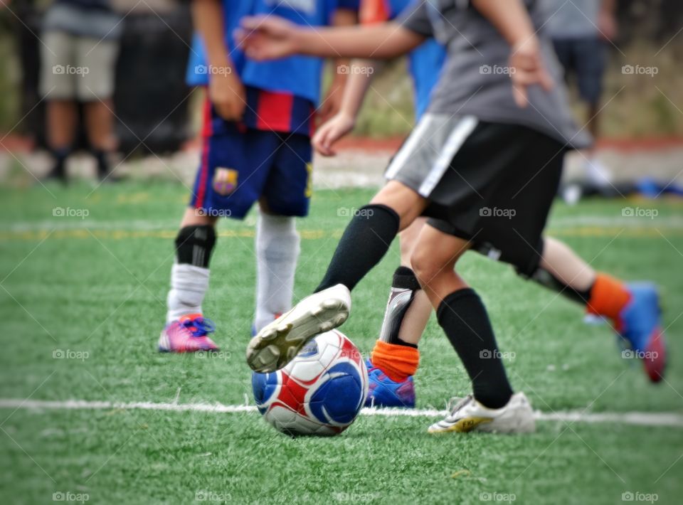 Youth Soccer. Children Kicking A Soccer Ball
