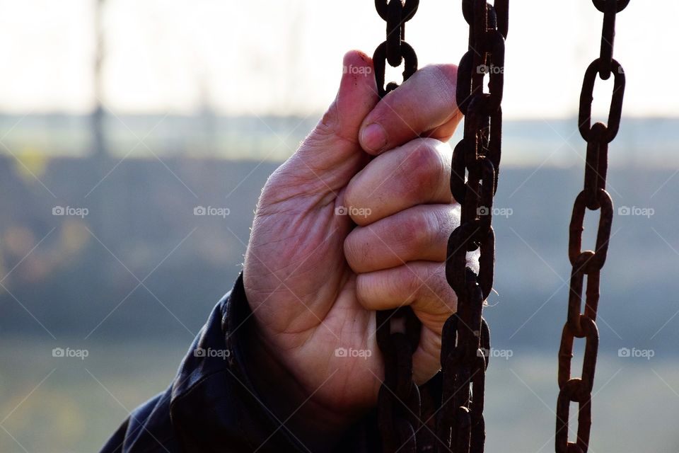Man hand holding a chain close up