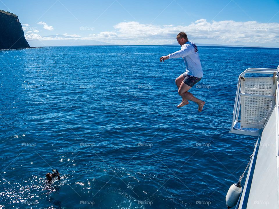 Summer fun includes jumping into the warm Pacific Ocean off the Hawaiian island of Lanai'i