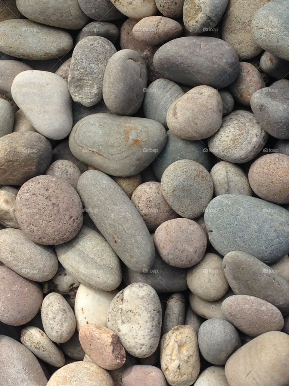 Grey pebble stones zen on beach rock background 