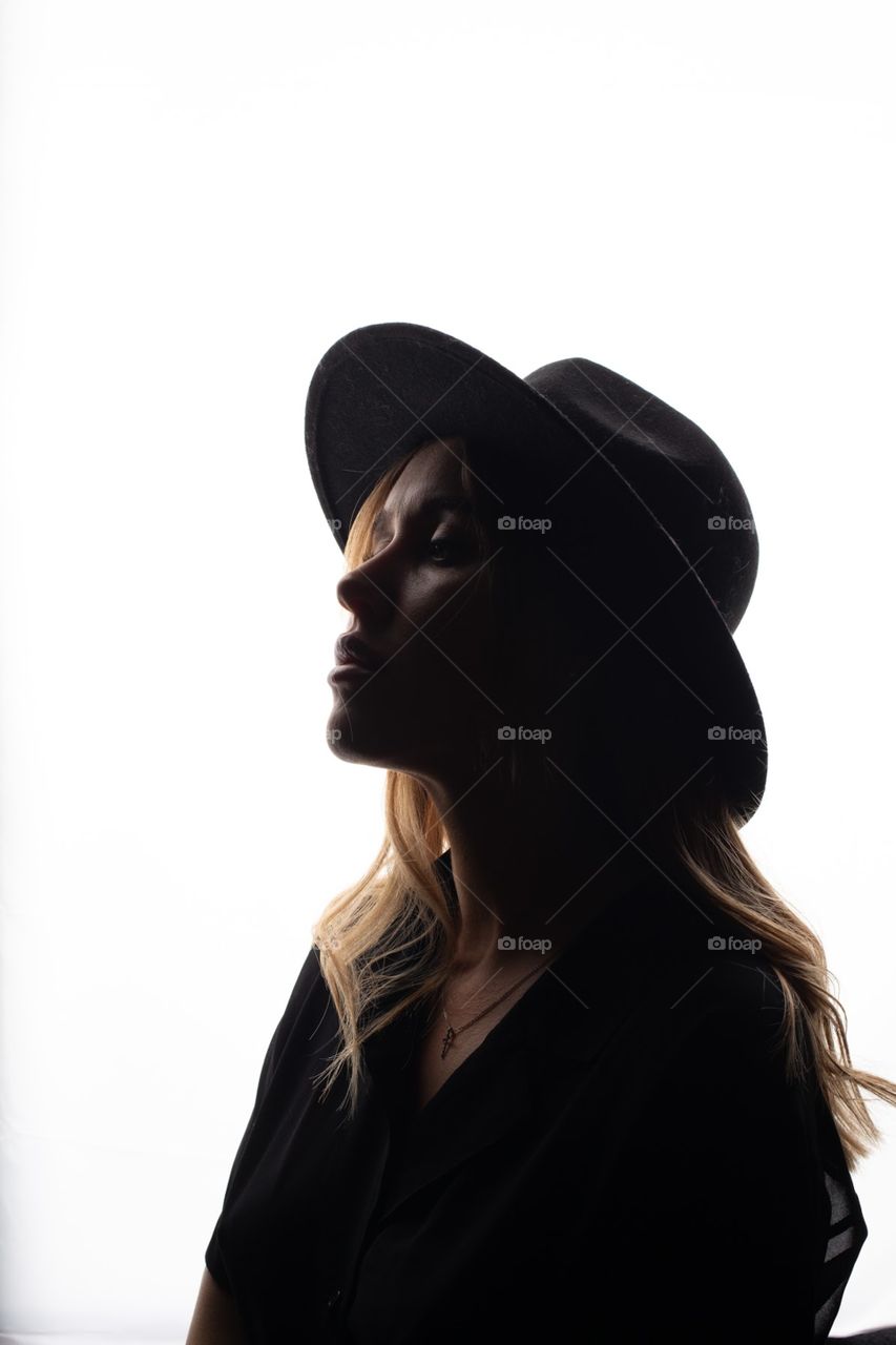 Fashion portrait of girl in hat in backlit 