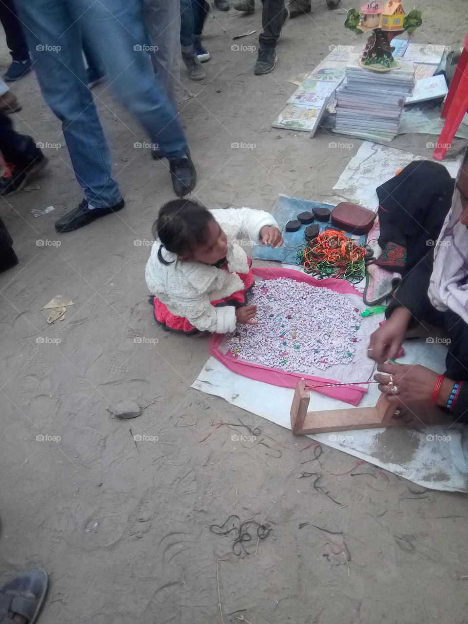 art-an Indian woman is making a bracelet in a Fair.