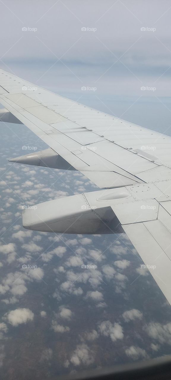 Clouds and Airplane wings view from window seat on Airplane