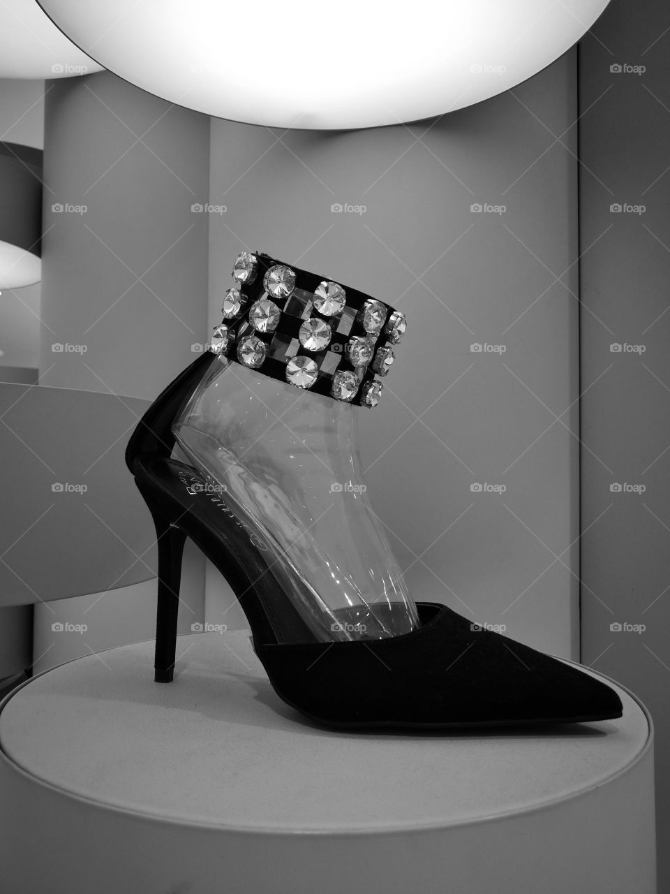 Black and white photo of elegant black stiletto with diamond decorated band on beautiful display