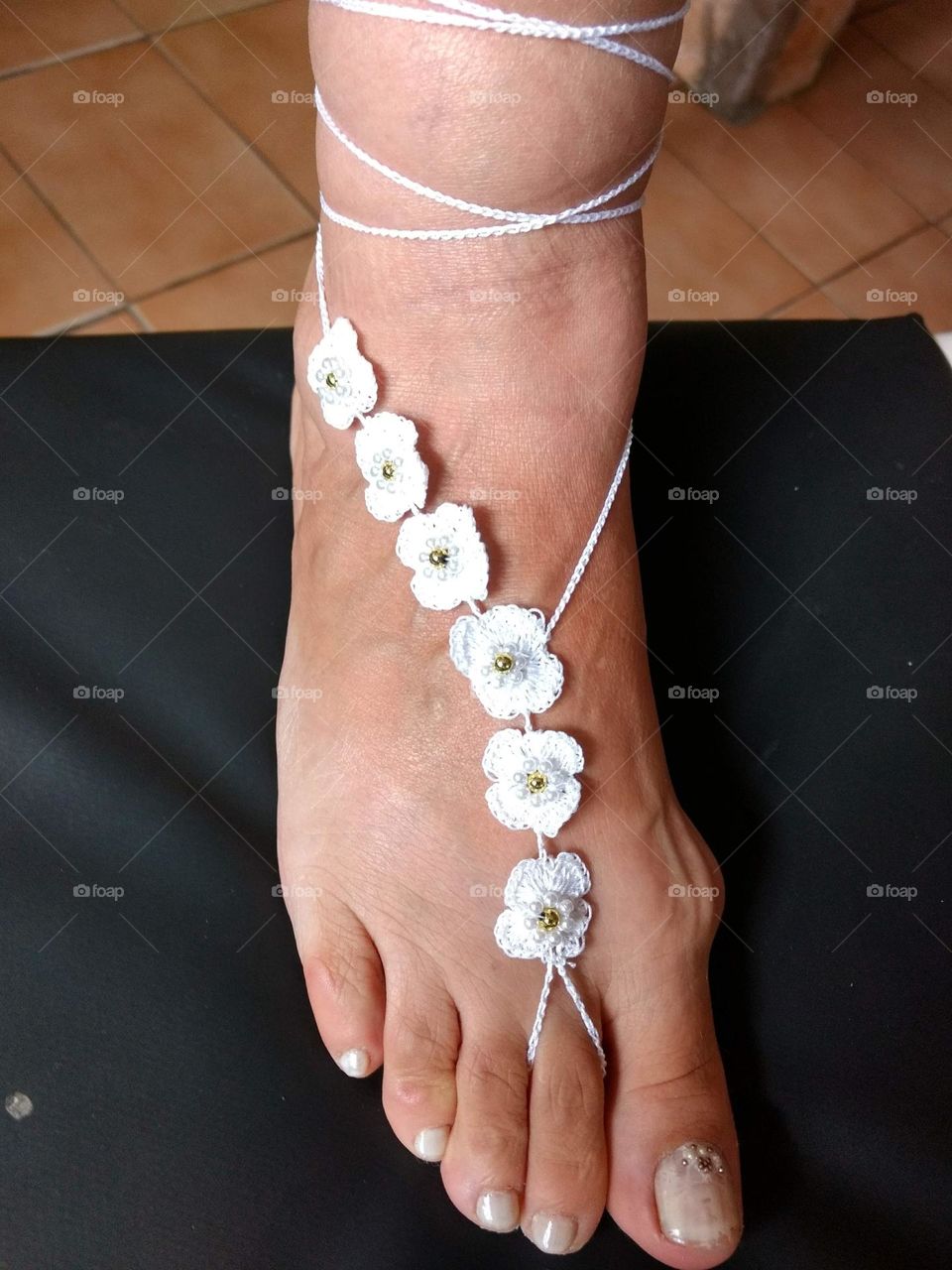 The elegance of bare feet decorated with small crochet flowers.