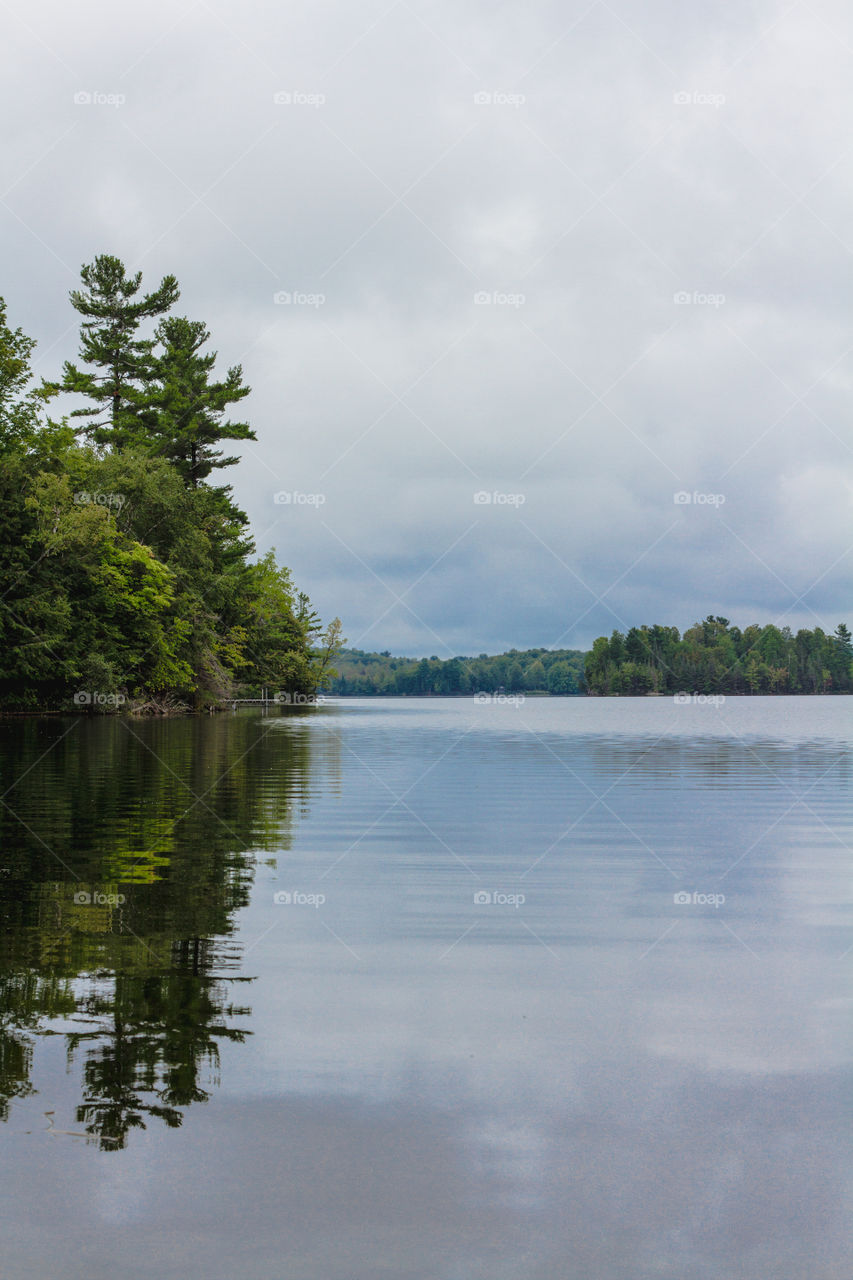 Looking across the lake with the sky reflecting on the water in cottage country