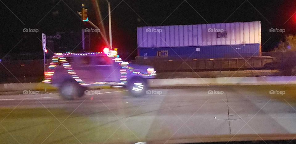 this truck was driving along with lights around it for the holidays