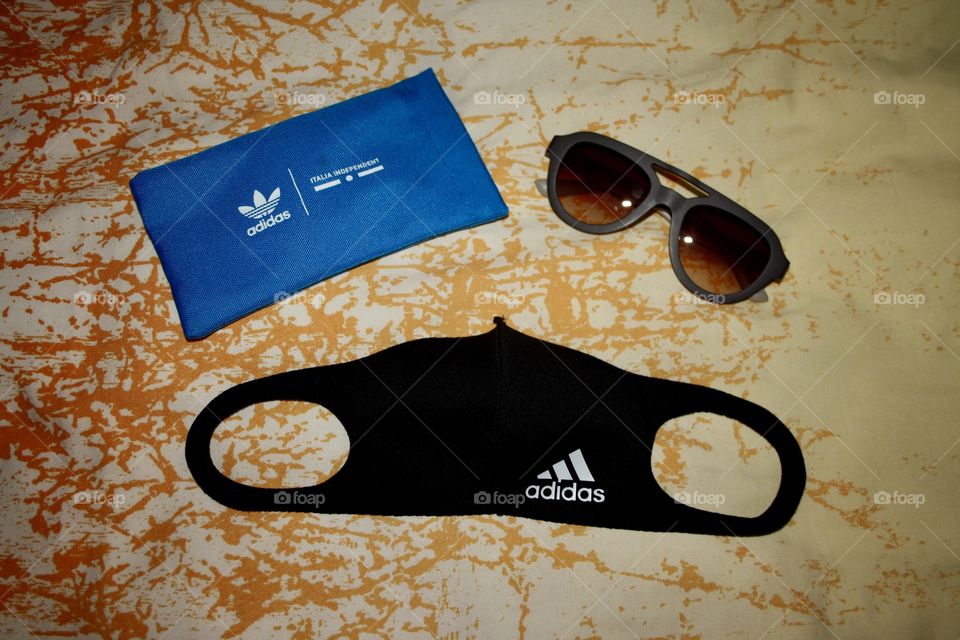 It is a mask to protect us from the coronavirus. The mask is from adidas. Next to the mask I have put some adidas sunglasses. There is also the case of the sunglasses.