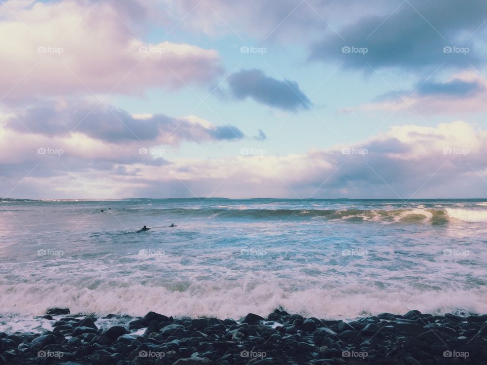 Cotton candy skies and surfers
