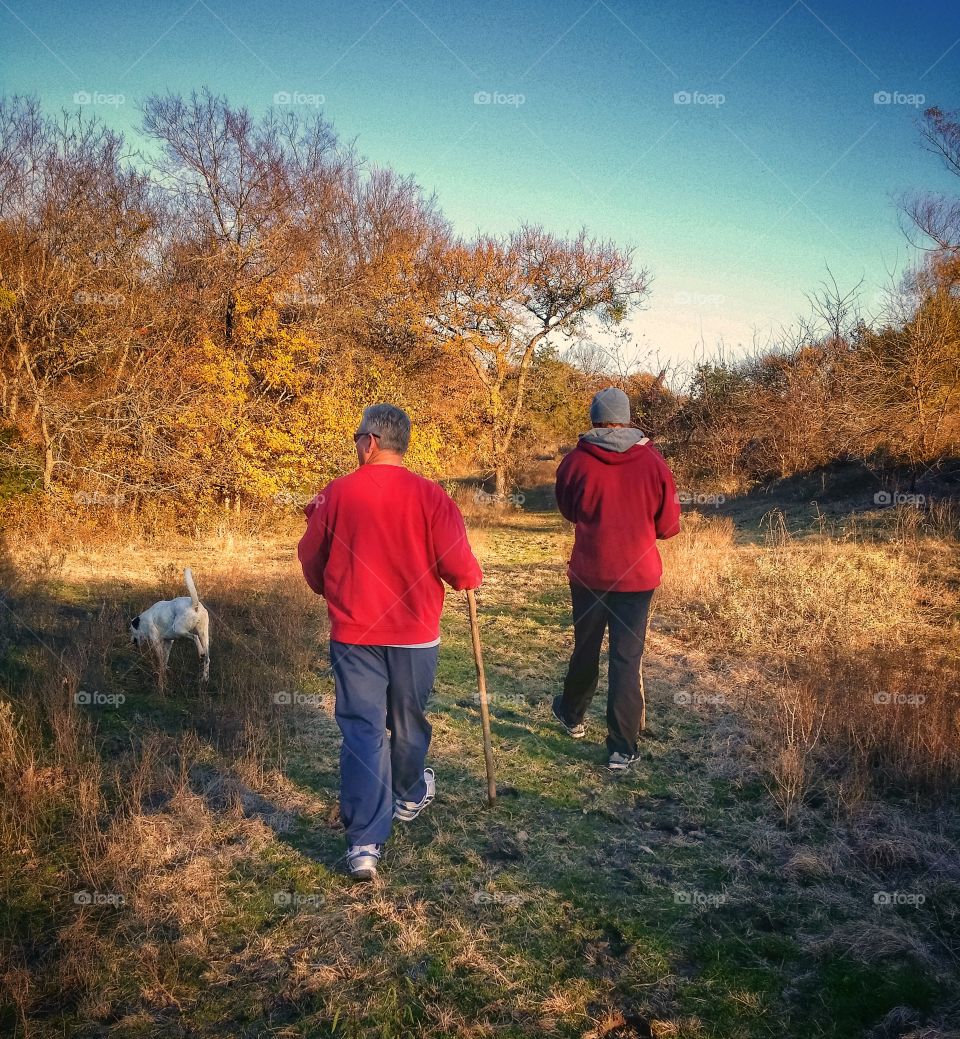 Two men hiking with their dog on a beautiful fall day a great hobby