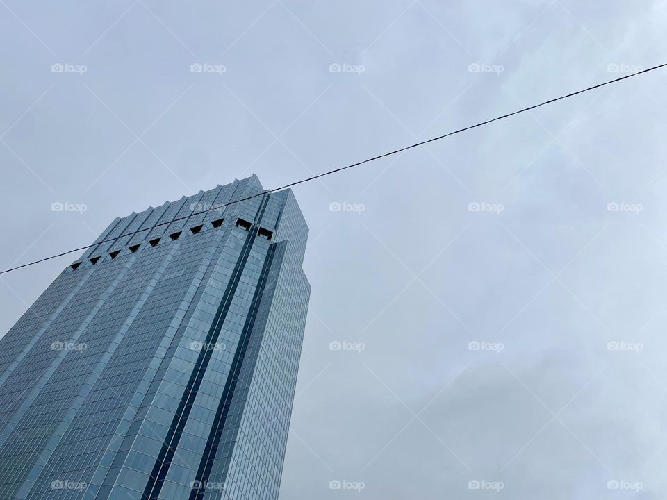 Tall grey skyscraper against grey sky
