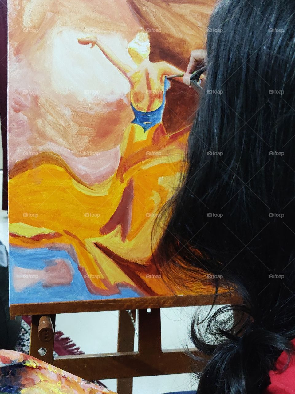 young woman on her canvas doing an oil painting