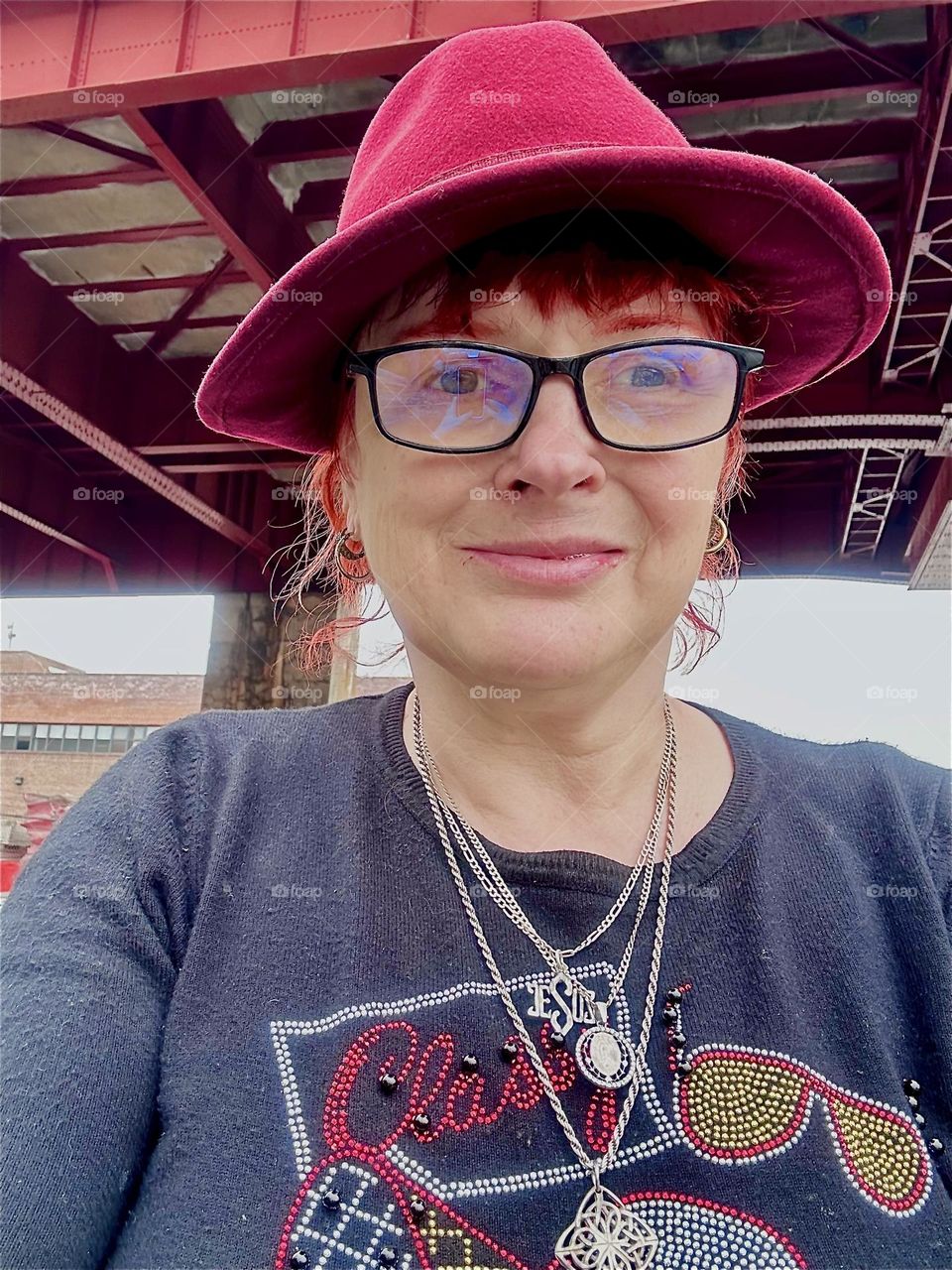 This is me, “Petra Schiller” a.k.a. “Maxine Firefox” a.k.a. “Maximiliane Feuerfuchs” standing in the parking lot beneath the “Pulaski Bridge” at “Newtown Creek” in LIC, Queens on a slightly overcast day in May of 2024. Hypnotic Productions