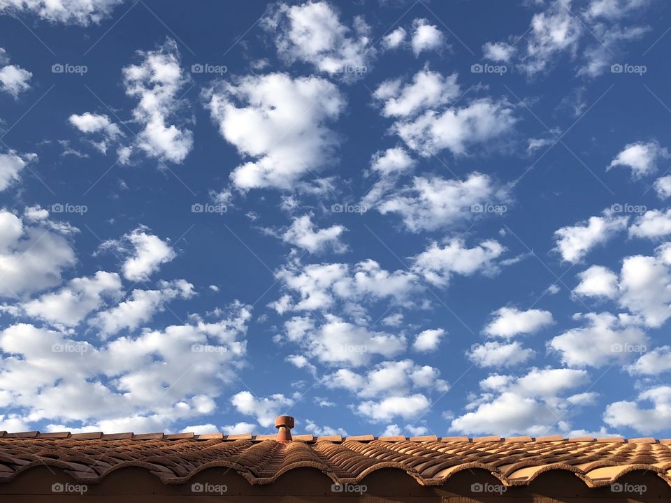 Puffs of cloud fill the morning sky above the clay roof tiles.