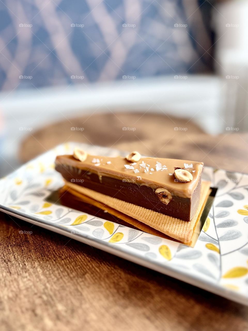 A slice of decadent chocolate and caramel cake topped with sea salt on a shortbread crust