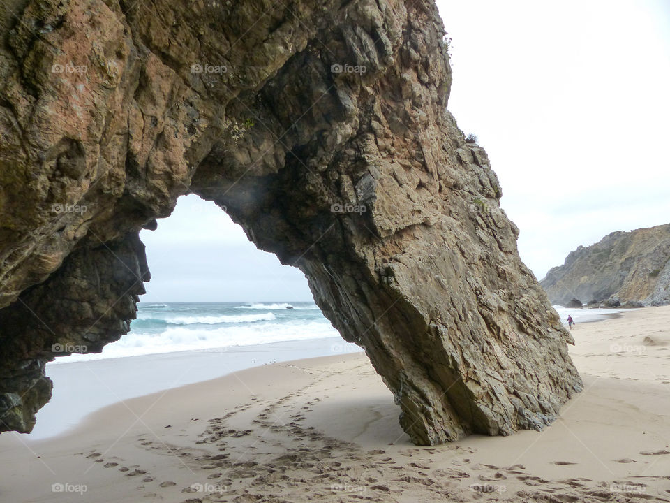 Natural rock archb. A natural rock arch on a beach near Sintra Portugal