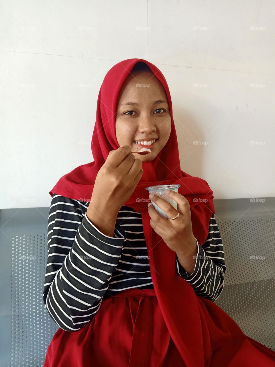 Woman holding ice cream scoop, looking at camera