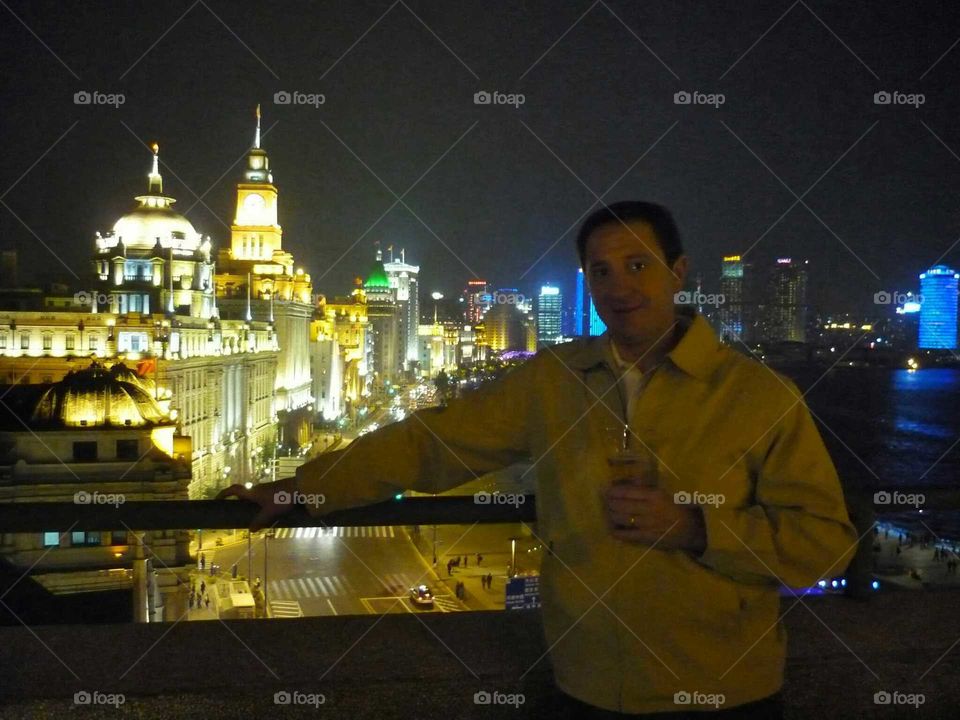 shangai at night. man drinking a beer at night in shangai