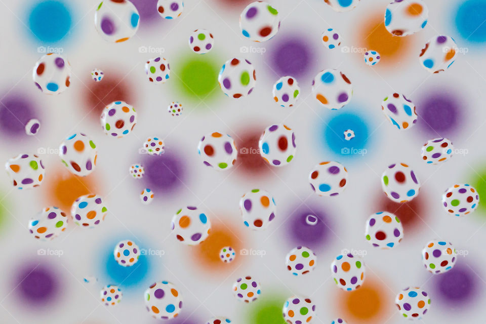 Shapes circles and ellipses using bright colorful circle background and many water drops reflecting the shape