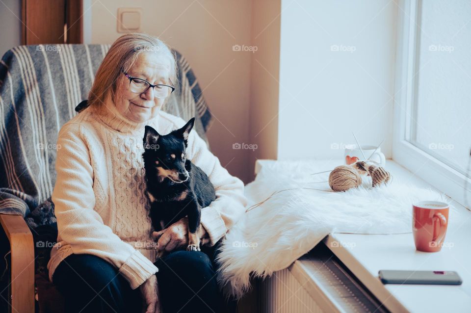 Old woman with dog at home