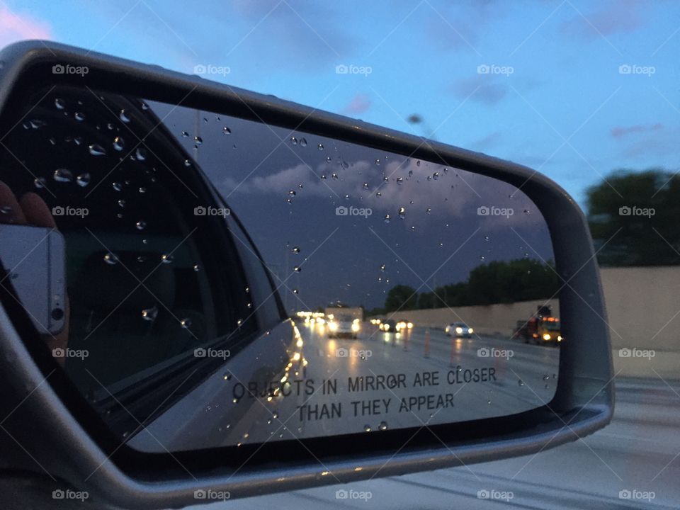 Objects in the rear view. Northbound on I95 leaving Miami after a long days work under a poetic sunset. Yet we focus on traffic.  