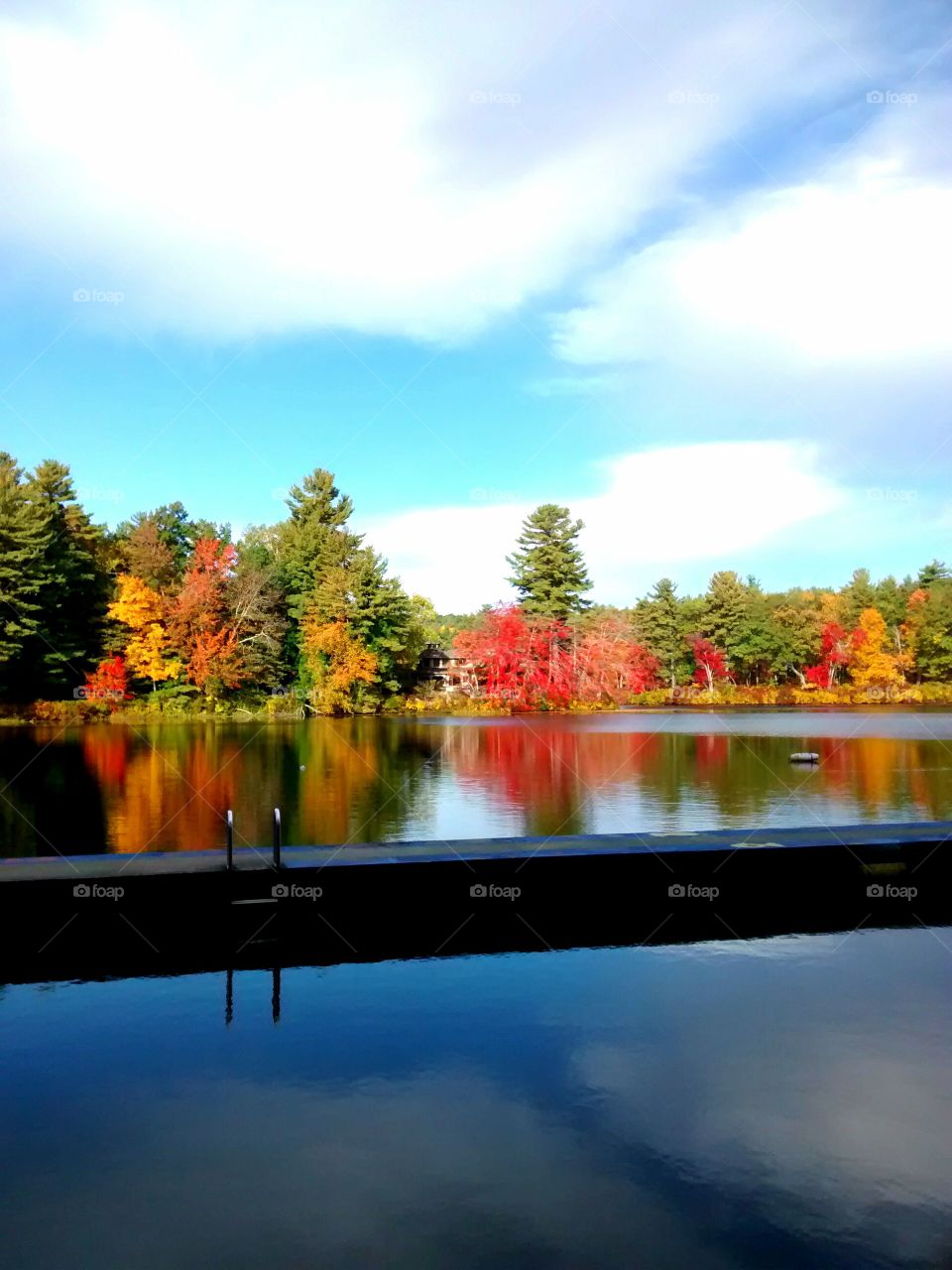 scenic view from the dock. Red, yellow and orange foliage peaks along the shores acids from the camps boat dock.