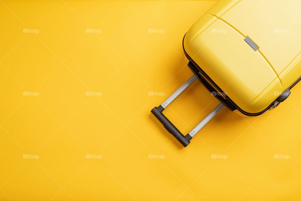 yellow suitcase on solid background