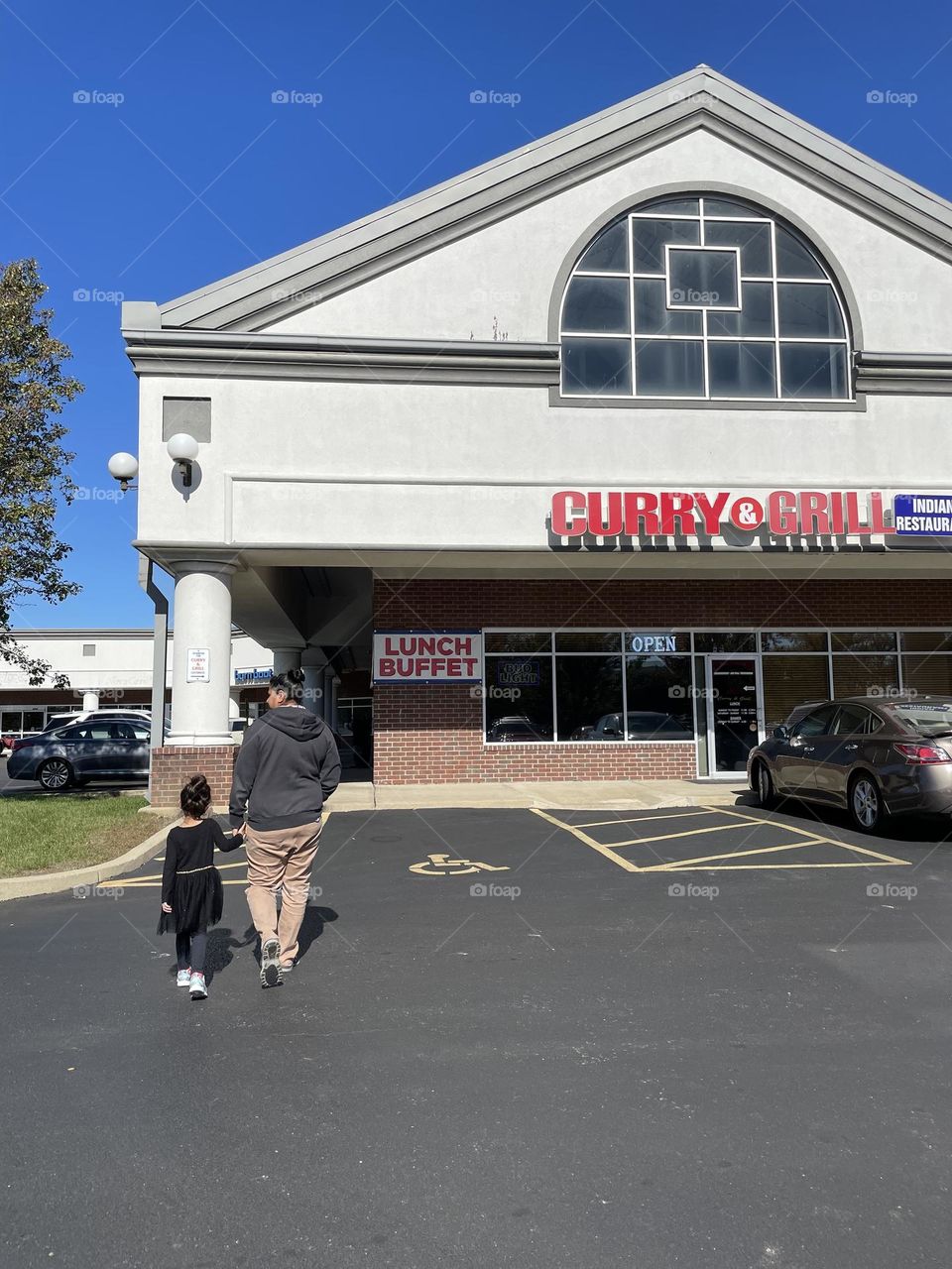 Mother and daughter walk into Curry and Grill restaurant, ready to eat lunch buffet, delicious food from India 