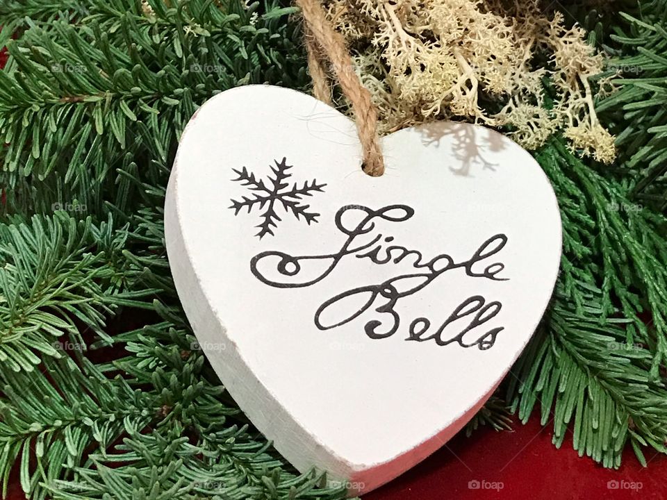 A wooden white heart with text jingle bells for Christmas 