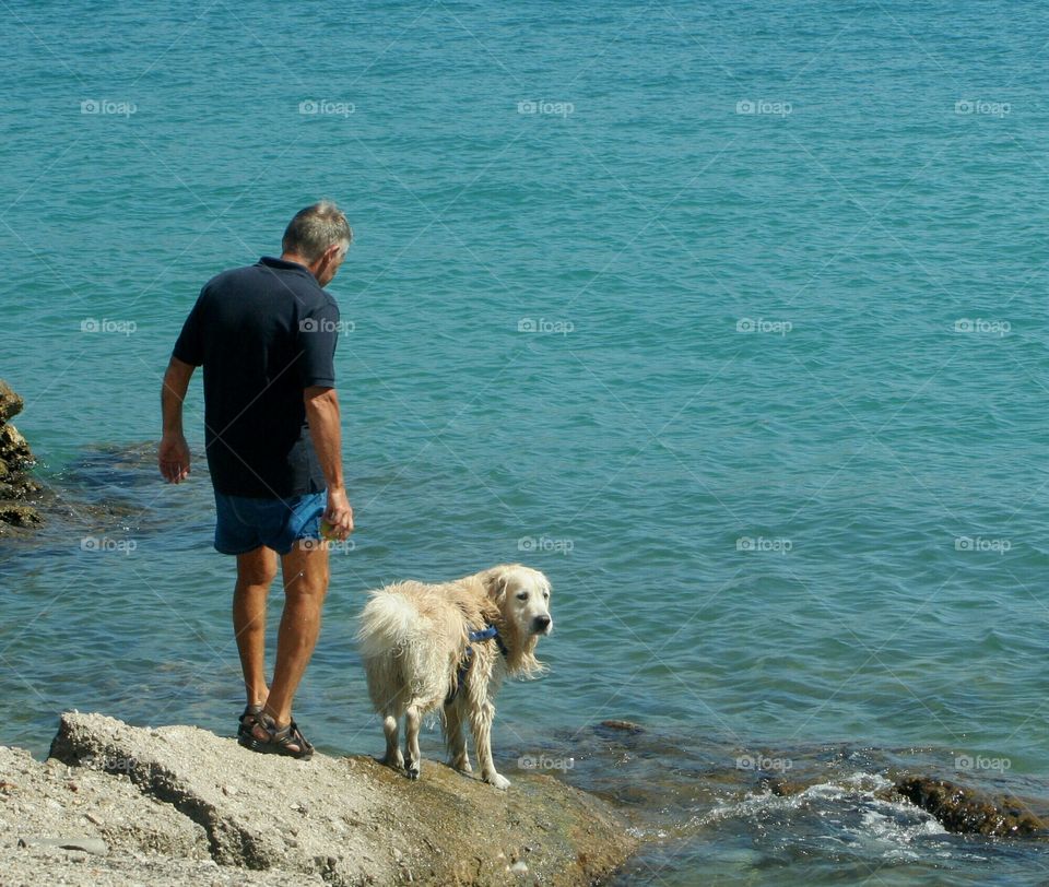 Old man plays with his dog in the morning