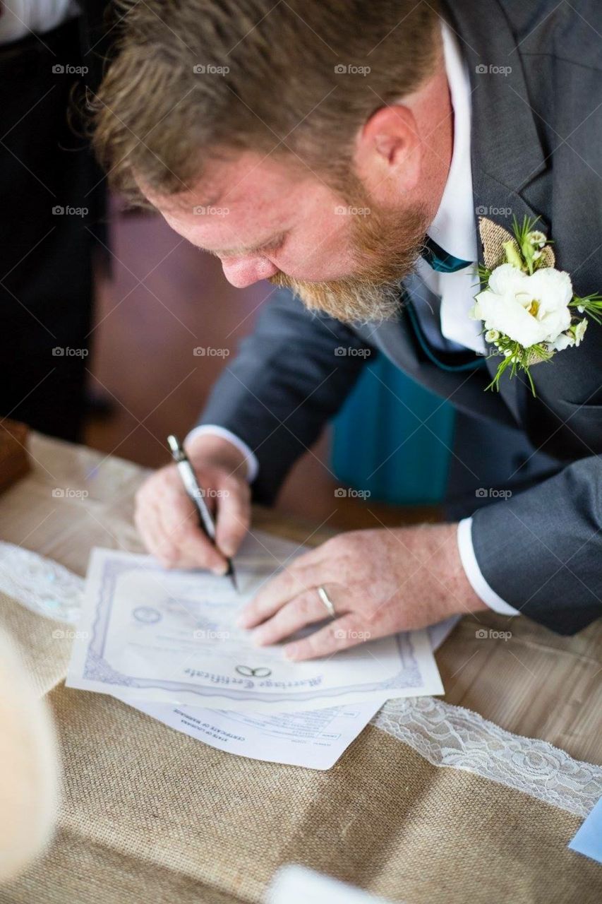 Groom signing marriage license 